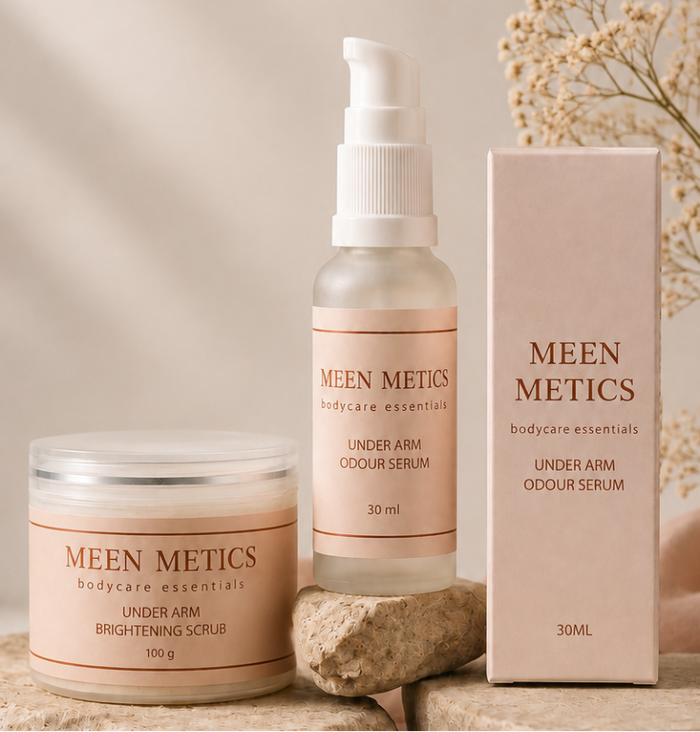 Three MEEN METICS skincare products arranged on stone blocks with soft beige fabric and dried flowers: a jar labeled Brightening Gold, a pump bottle labeled Under Arm Colour Lift, and a pink box labeled Under Arm Brightening Gold. Text on the image reads, 'Care today, Confidence always.